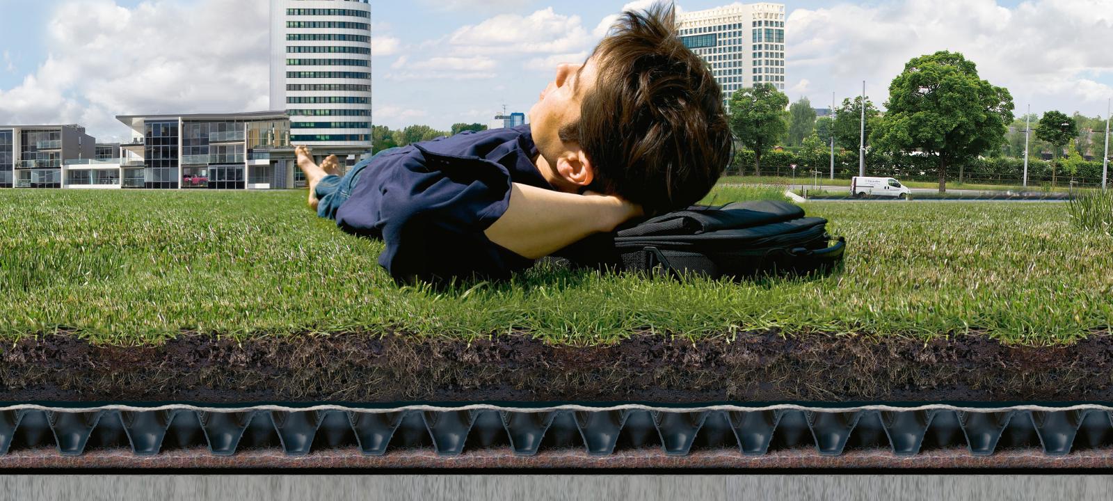 Man relaxing on a lawn established on a green roof system build-up